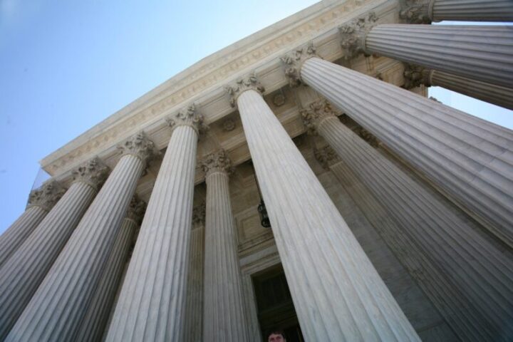 Dramatic low-angle view of courthouse columns representing strength and authority of legal institutions