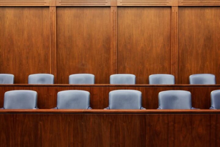 Courtroom jury box seating with wood paneling representing legal proceedings and justice system